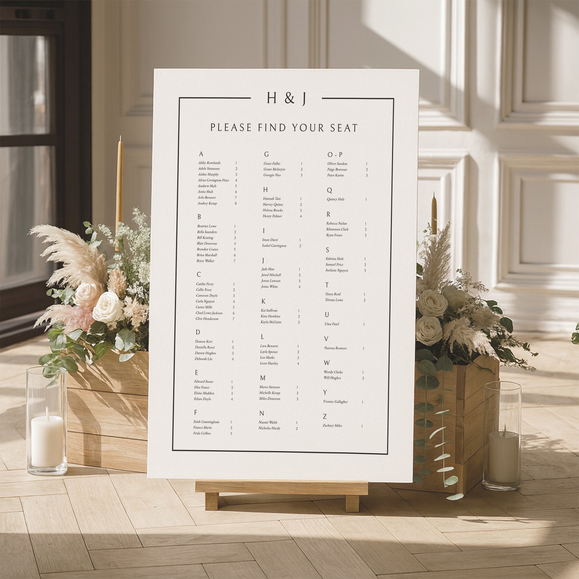 Modern alphabetical seating chart for a wedding with floral arrangements and candles in a room.