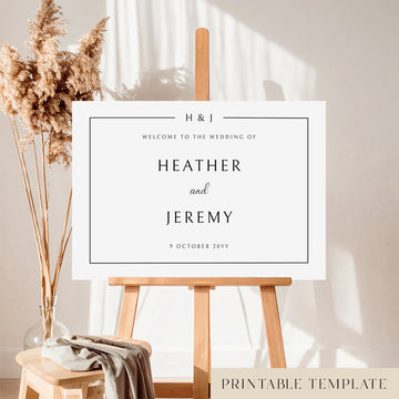 A horizontal printable wedding welcome sign template displayed on a wooden easel with a decorative dried plant in the background.