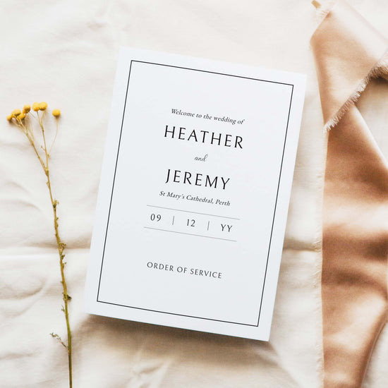 A5 wedding Mass ceremony booklet cover, photographed on light fabric with minimal floral styling.