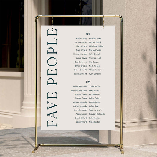 Two long tables wedding seating plan with 'FAVE PEOPLE' text on a gold stand against a neutral wall.