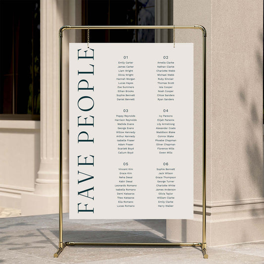 6-table wedding seating plan with 'FAVE PEOPLE' text on a gold stand against a neutral wall.