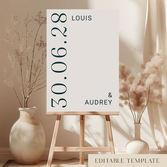 Modern typographic wedding welcome sign from the Palais collection, displayed on a wooden easel. Features a unique vertical date layout and minimalist editorial styling. DIY printable A1 poster template by The Hello Bureau.
