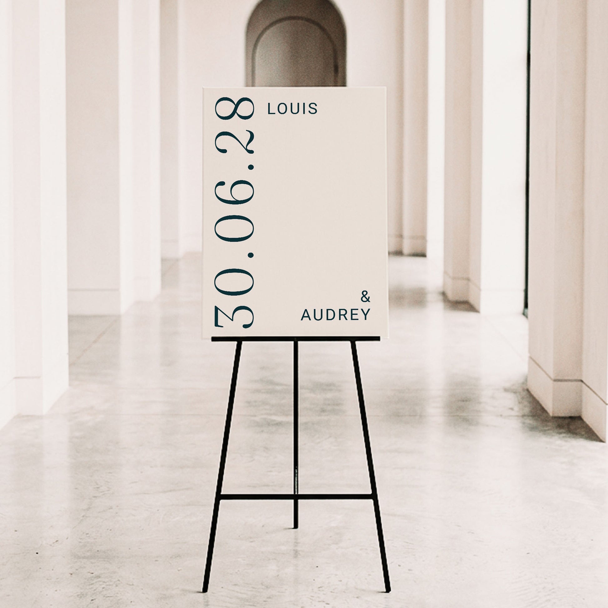 Minimalist wedding entry sign with bold serif typography on a black metal tripod easel. The Palais design offers a clean, sophisticated look for contemporary Australian weddings. Personalise the names and date online with ease.