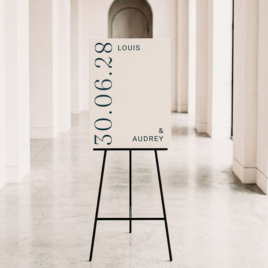 Minimalist wedding entry sign with bold serif typography on a black metal tripod easel. The Palais design offers a clean, sophisticated look for contemporary Australian weddings. Personalise the names and date online with ease.