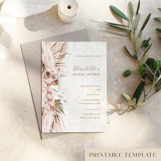 Bridal shower invitation card with pink floral design on a textured surface with olive branches.