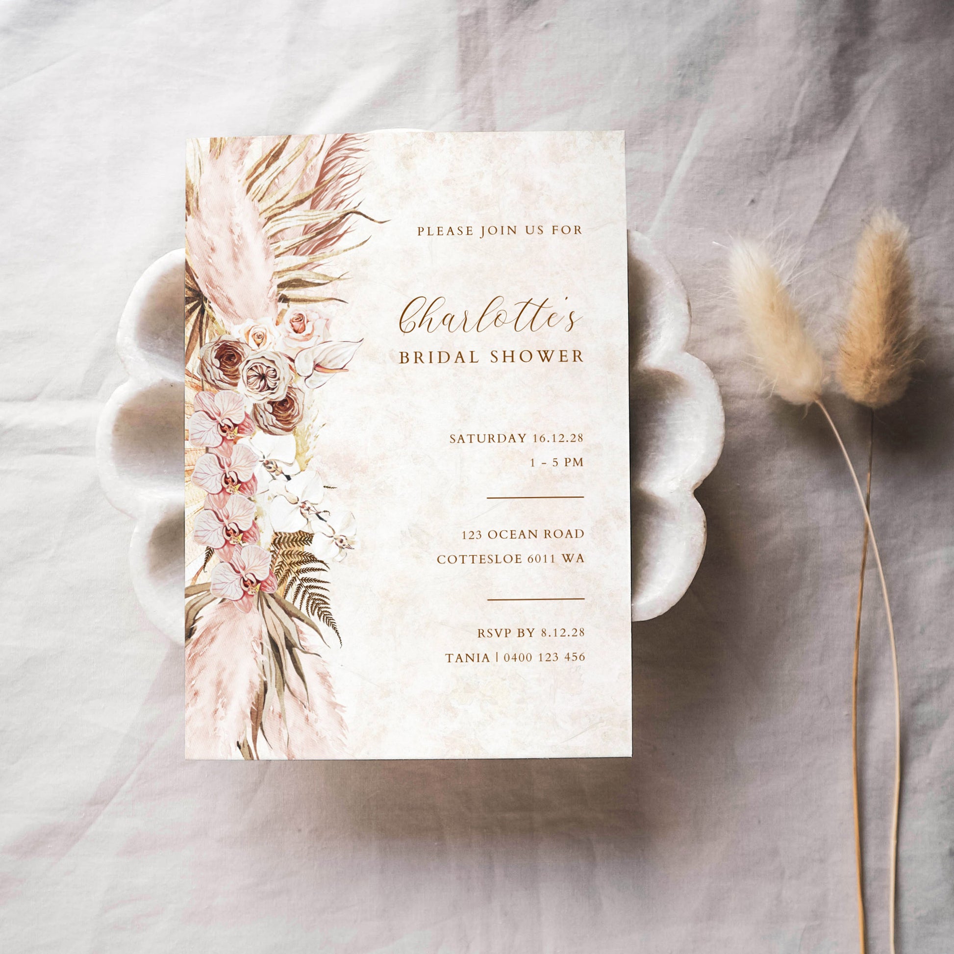 Bridal shower invitation template design on textured paper with dried flowers.