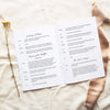 Open A5 wedding Mass ceremony booklet displaying interior ceremony text on a neutral fabric background.