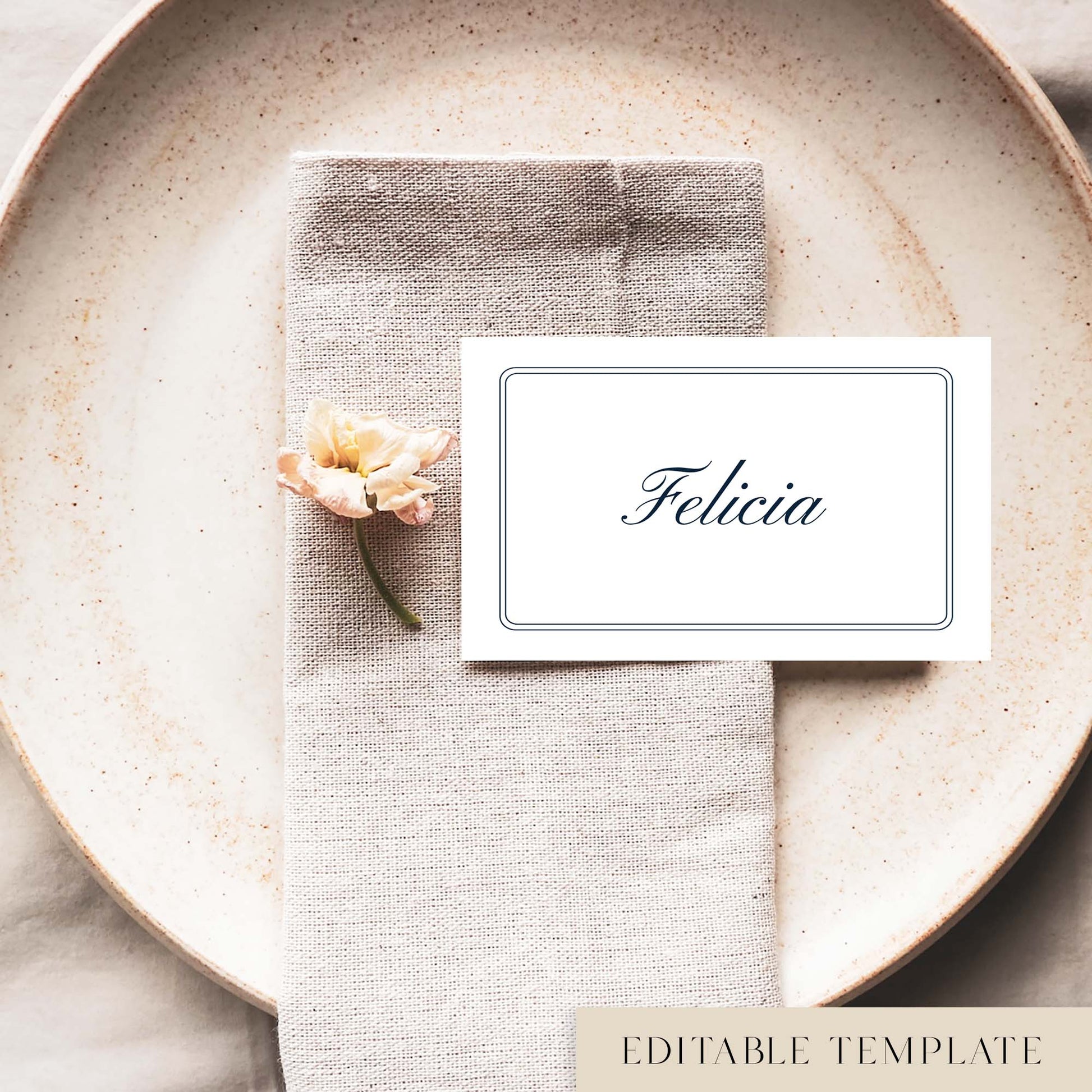 A flat place card with a border and name printed on it, positioned on a plate with a napkin and a floral decoration.