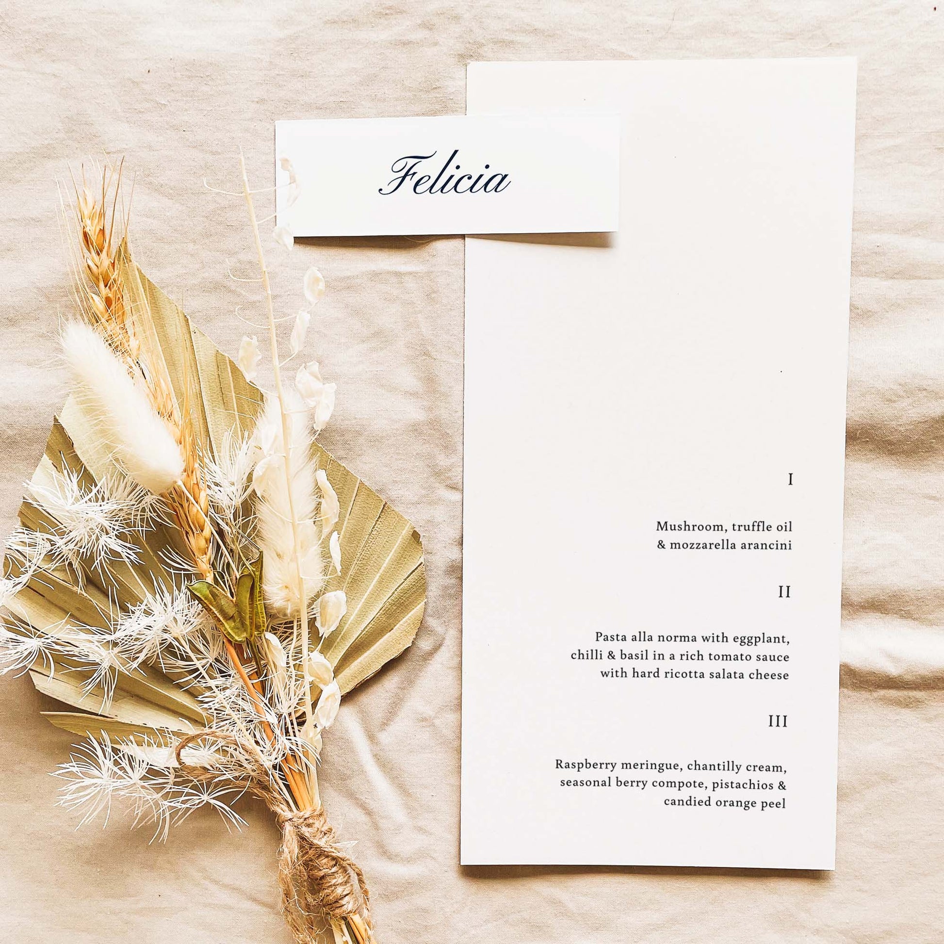 A long place card with name placed on the top corner of a DL sized menu.