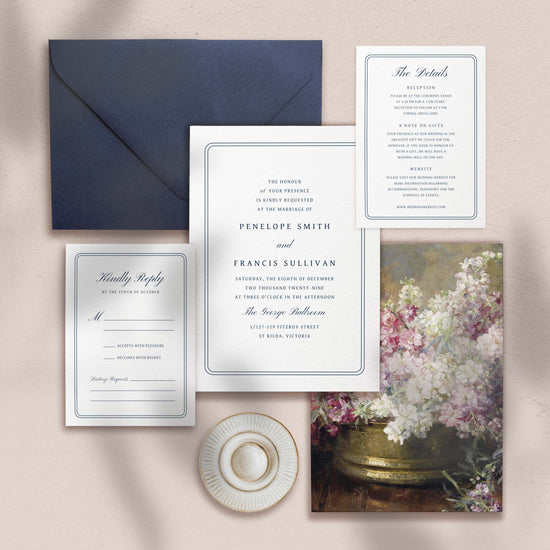 Wedding invitation, details card, RSVP card and envelope on a textured surface.