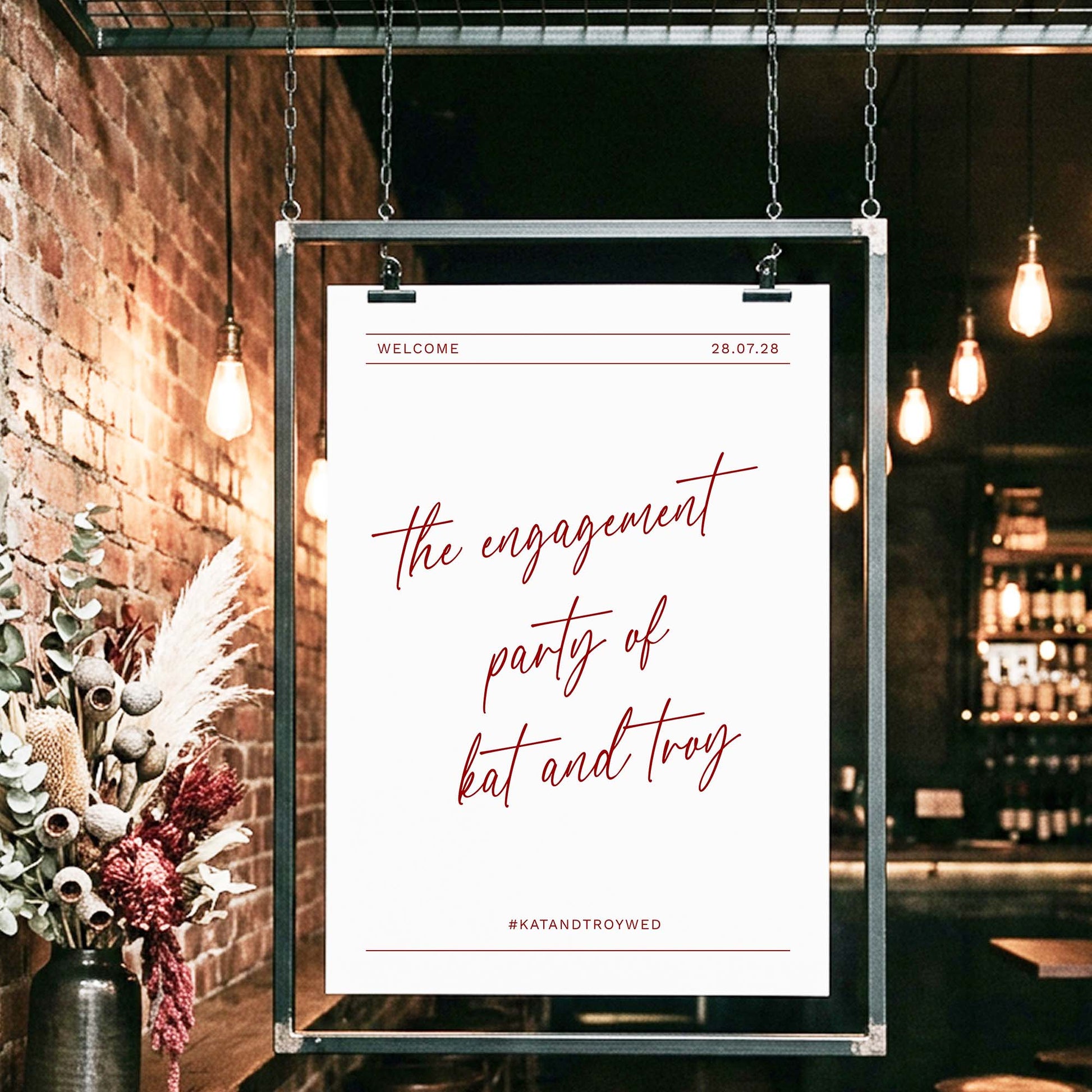 Informal engagement party welcome sign in a black hanging frame.