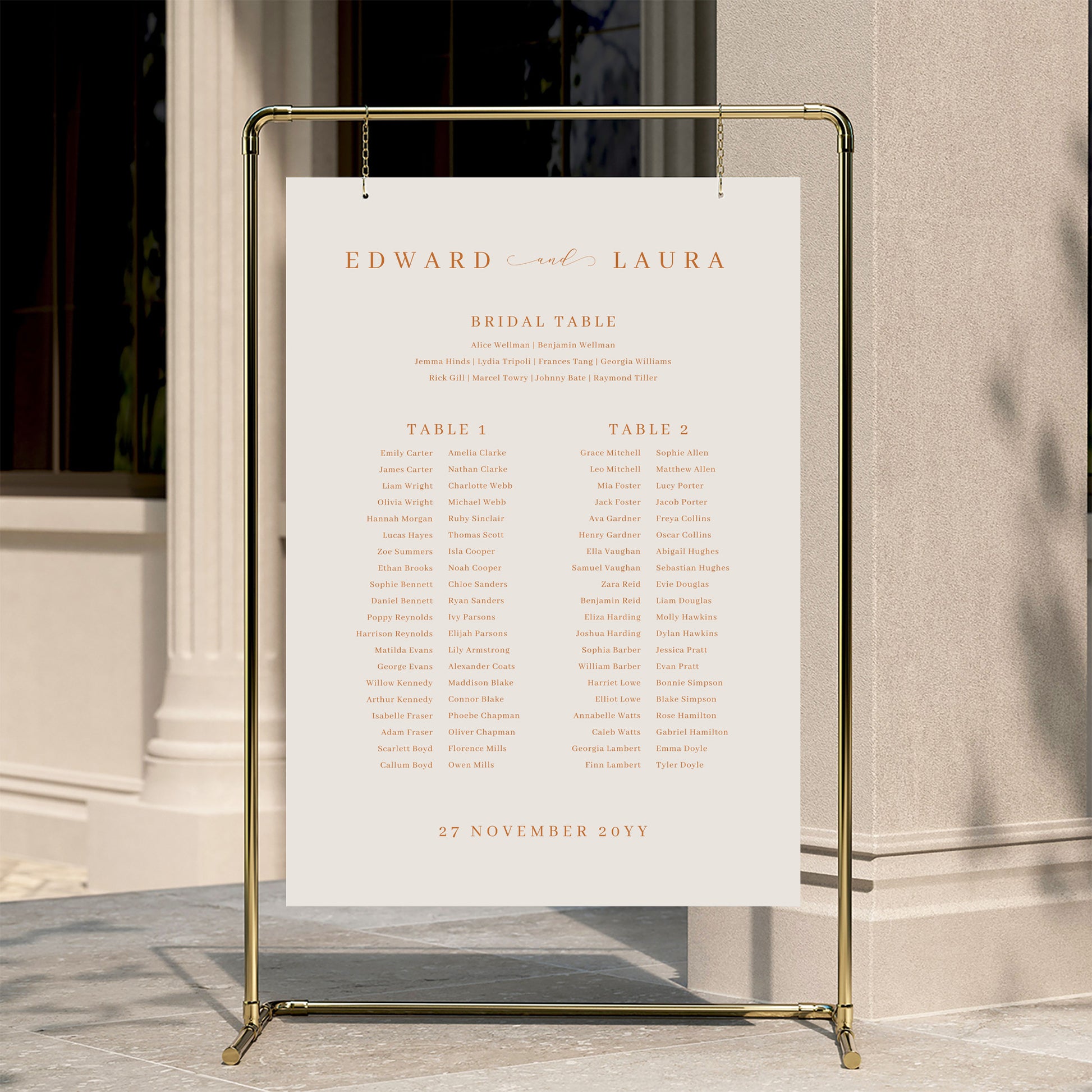 Minimal wedding seating chart template displayed on a gold stand against a neutral wall.