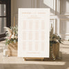 Printable elegant wedding seating chart sign on an easel with floral arrangements in a room setting.