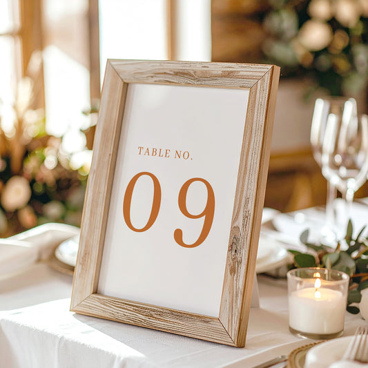 Printable table number card displayed on a wooden stand on a linen table cloth.