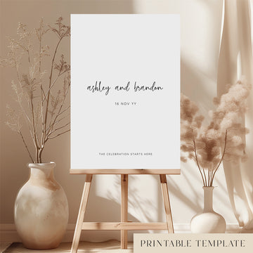 Printable minimal wedding welcome sign on an easel with floral arrangements in a room setting.