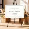 Modern welcome sign template on an easel with floral arrangements and candles in a decorative setting.