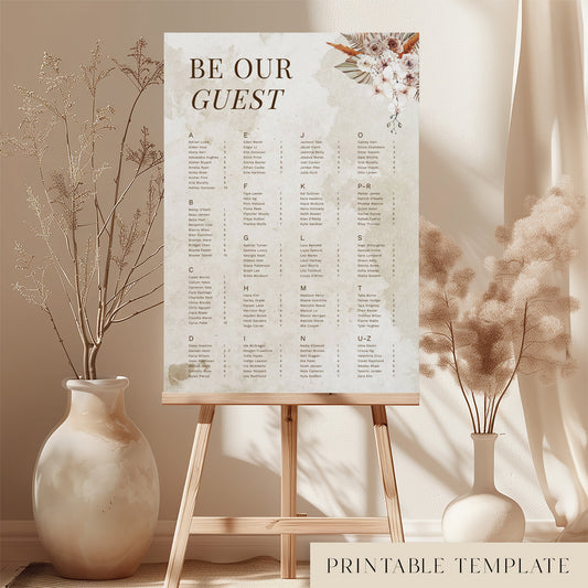 Printable alphabetical wedding seating chart sign on an easel with floral arrangements in a room setting.