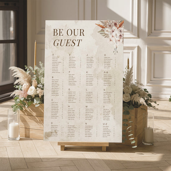 Modern boho floral alphabetical seating chart for a wedding with floral arrangements and candles in a room.