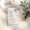 Modern boho save the date template design printed on a white card sitting on a textured surface with olive branches.