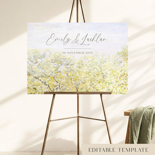 Monet spring orchard wedding welcome sign with elegant dark script names over a pale sky, displayed on a gold easel in a sunlit room.