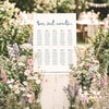 DIY whimsical 10-table wedding seating chart template styled at an outdoor wedding surrounded by wildflowers and greenery.