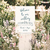Whimsical wedding welcome sign template with hand-drawn illustration in a warm, informal wedding setting.