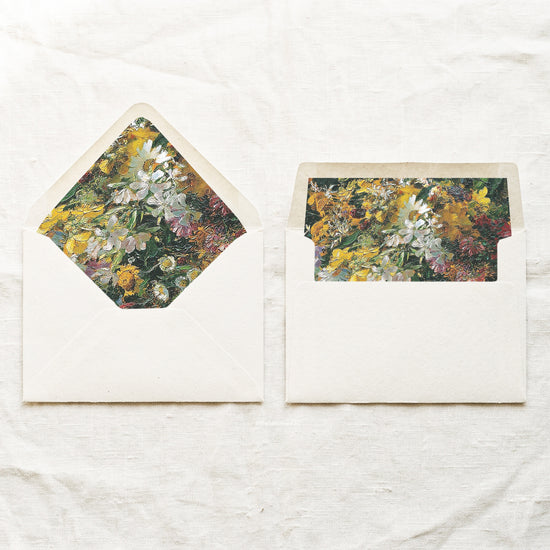 DIY painted floral envelope liners for 5x7 wedding invitations, shown in a euro flap and a straight flap in mustard yellow, white, green and pink on cream envelopes.