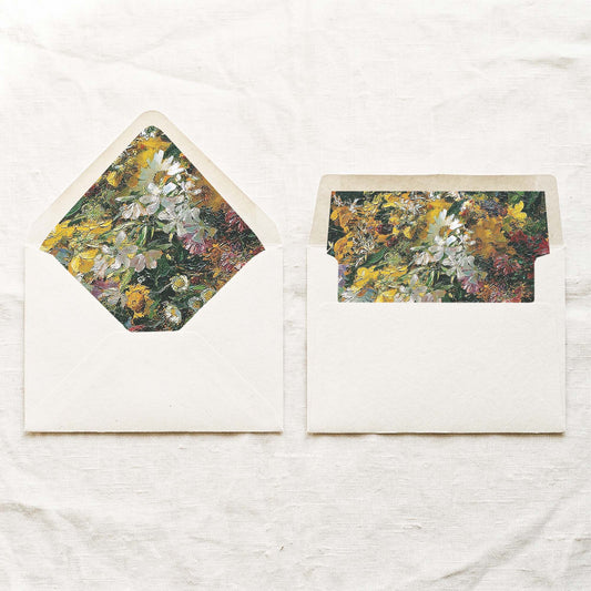 DIY painted floral envelope liners for 5x7 wedding invitations, shown in a euro flap and a straight flap in mustard yellow, white, green and pink on cream envelopes.